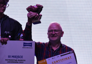 Nauczyciel podnosi trofeum